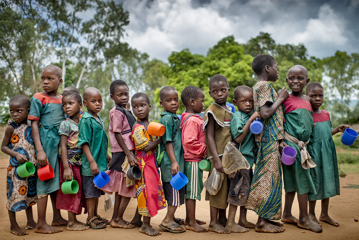 Children at a primary school in Malawi wait in queue for lunch as part of Save the Children’s nutrition programming in the community.